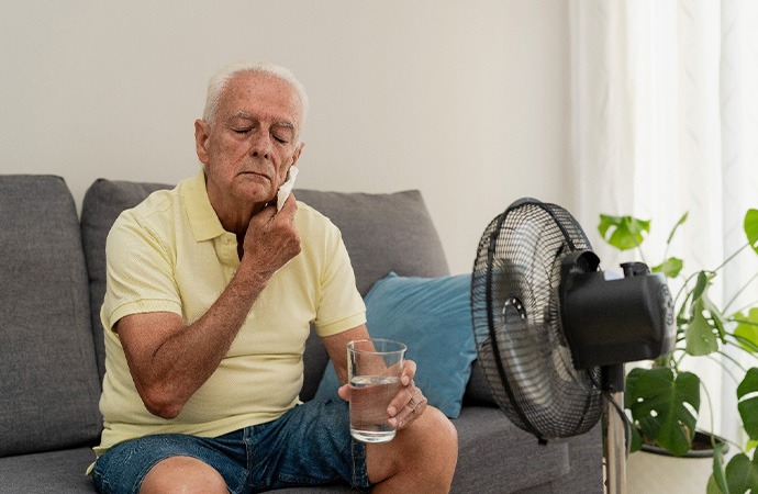 Man sitting on the couch and holding a glass of water