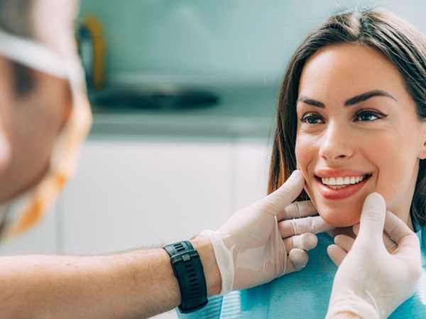 a patient smiling while visiting her dentist