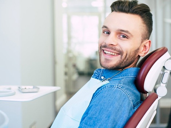 a patient smiling while visiting his dentist