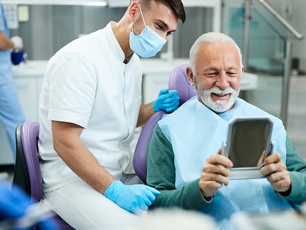 Patient looking at reflection in mirror with dentist