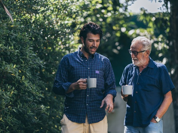Father and son enjoying coffee on their walk