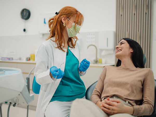 Smiling patient and dentist talking in treatment room