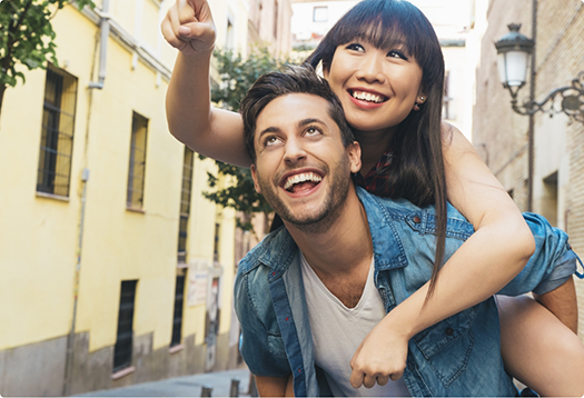 Smiling man and woman looking around a city