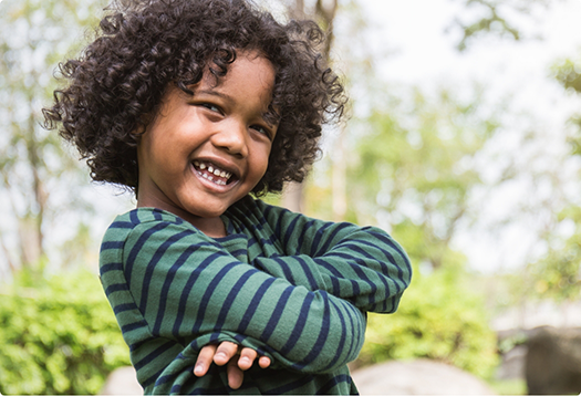 Child smiling with their arms crossed